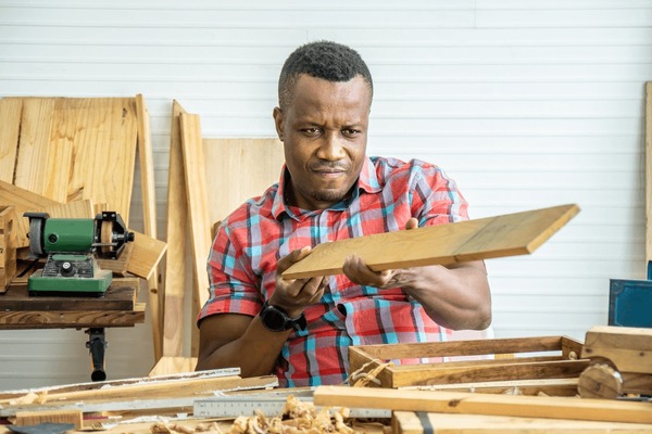 African carpenter working with wood in a workshop
